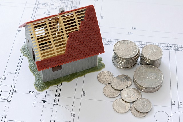 Une maison dont le toit est en construction et des pièce de monnaies à coté
